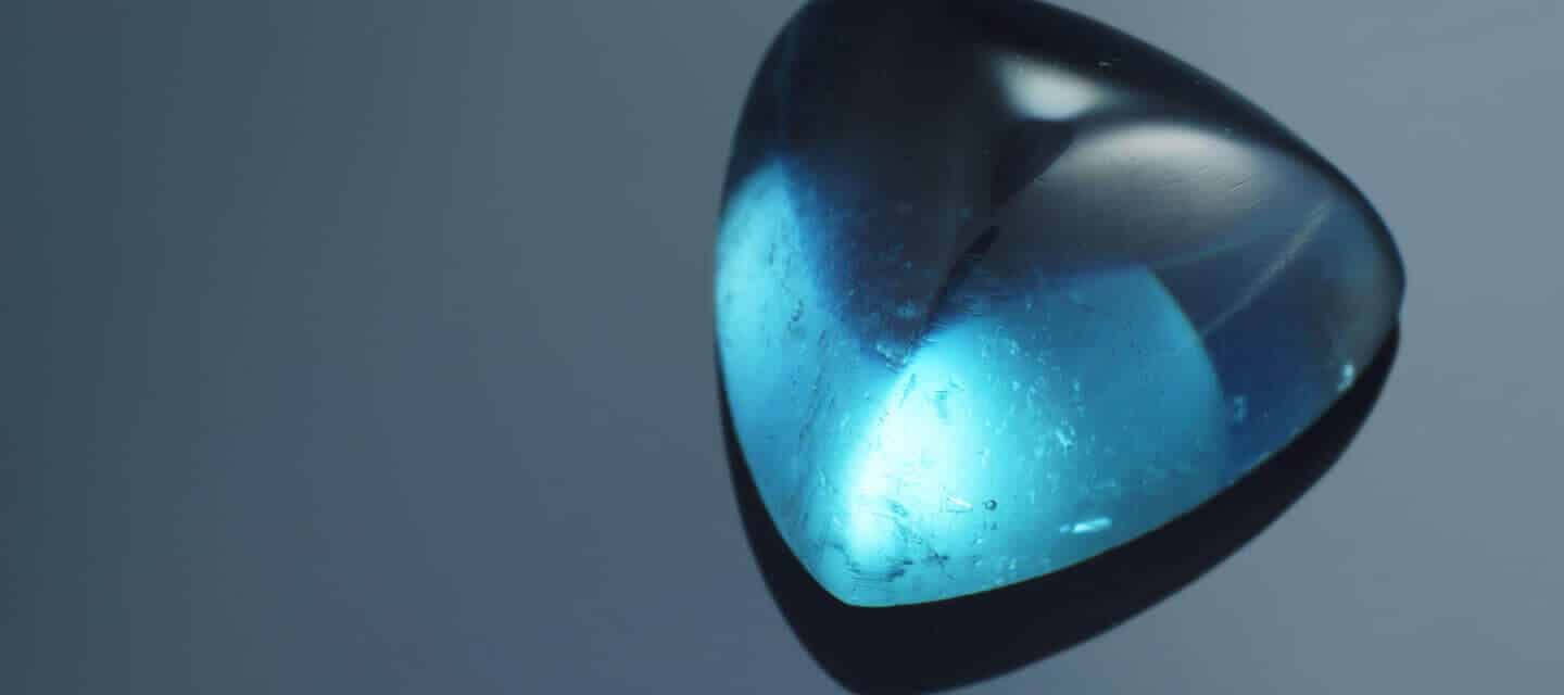 Large blue gemstone on plain background