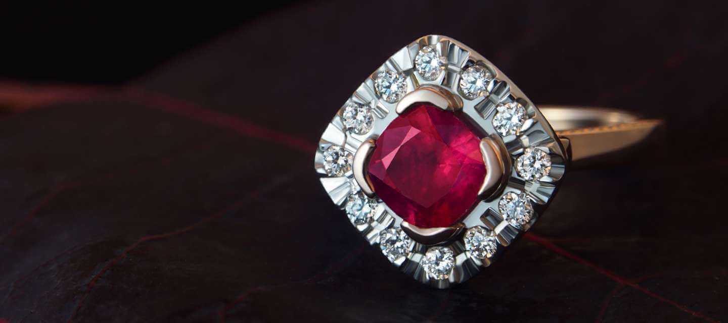 Ruby cluster engagement ring on black background