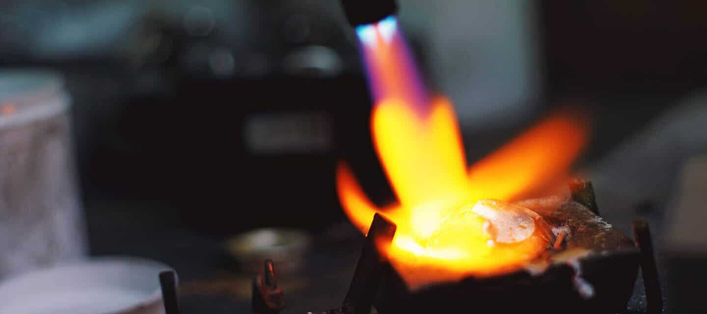 Blowtorch melting platinum in a crucible