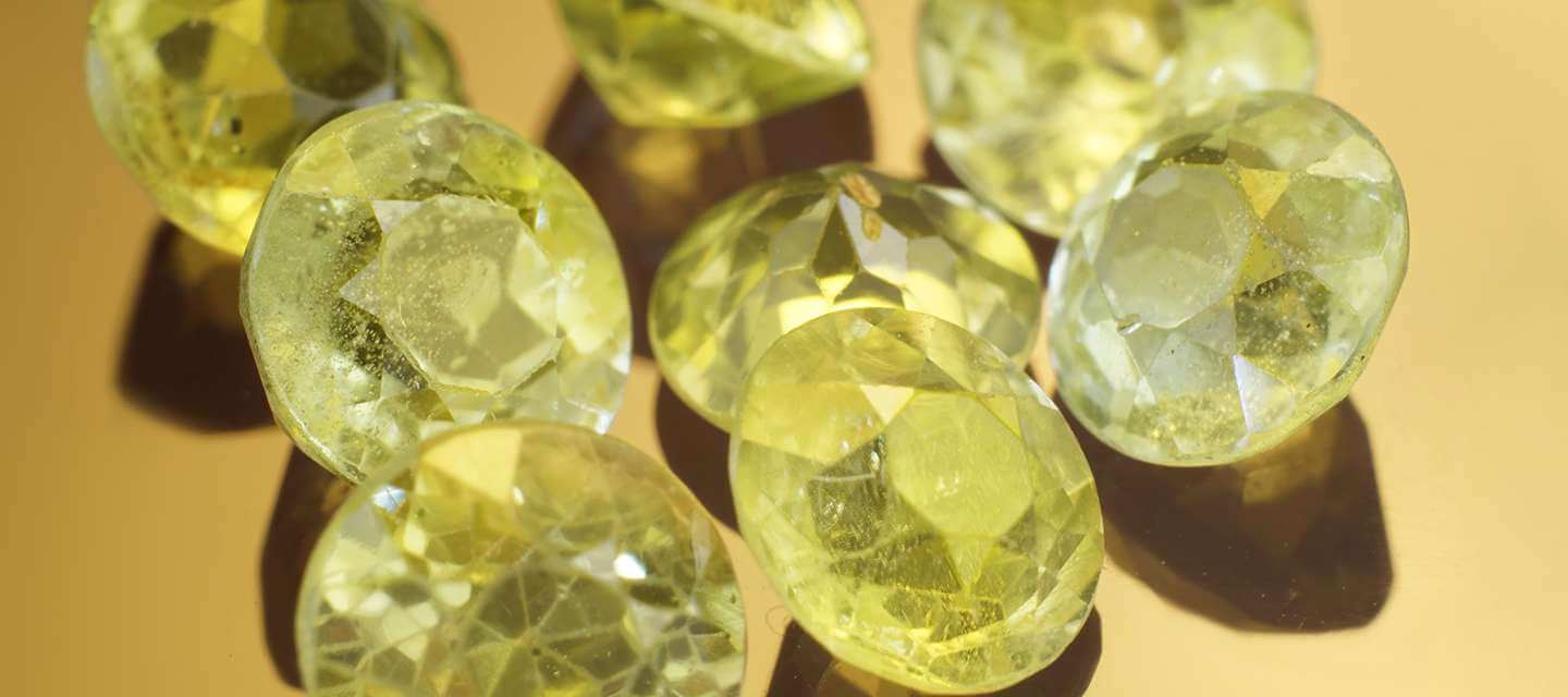 Green peridot gemstones on yellow background