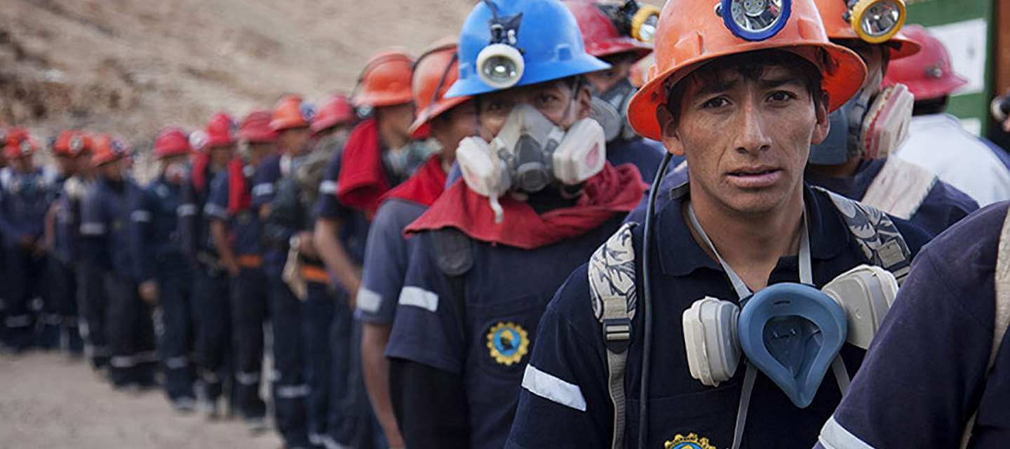 Group of fairtrade miners in linear formation