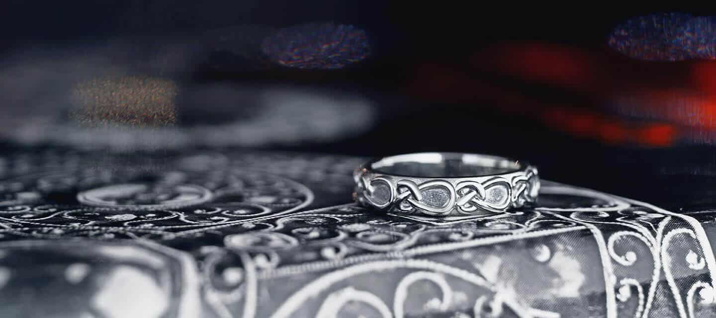 silver celtic patterned ring on a silver box