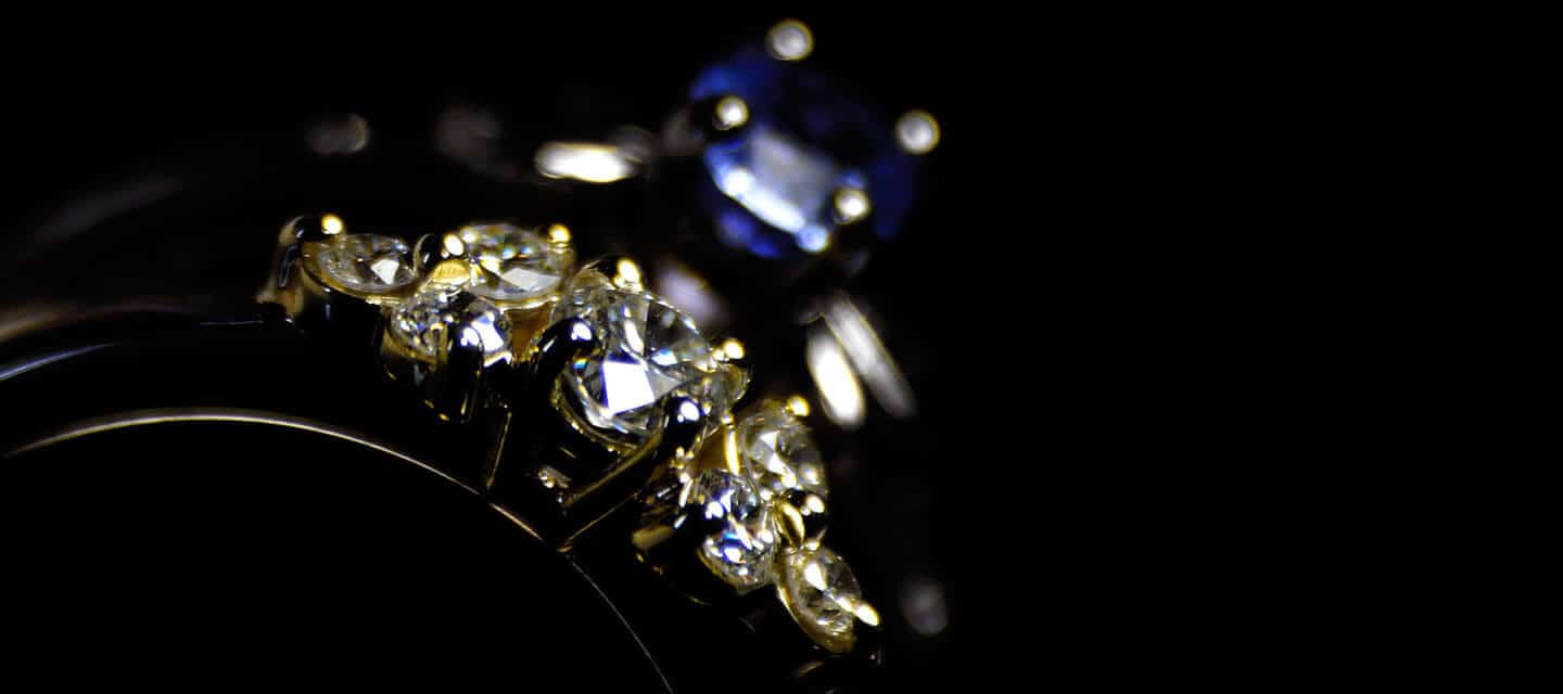 diamond and sapphire rings in dark background