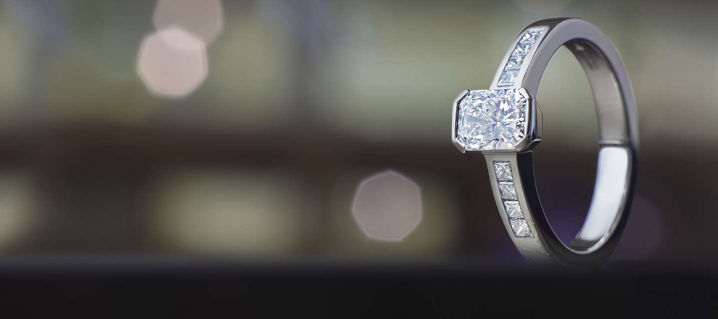 emerald cut diamond ring on blurred background