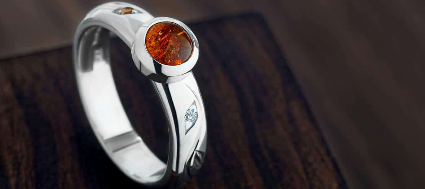 silver and amber ring on wood table