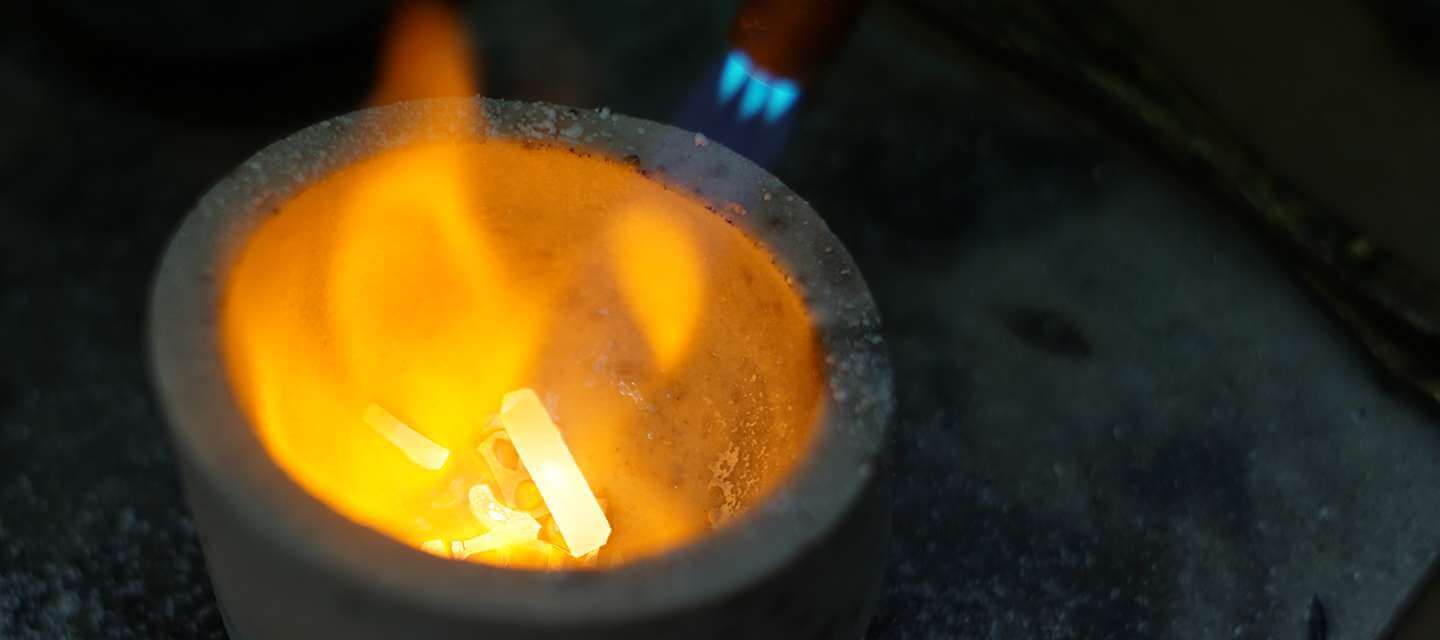 Crucible with metal under a flame