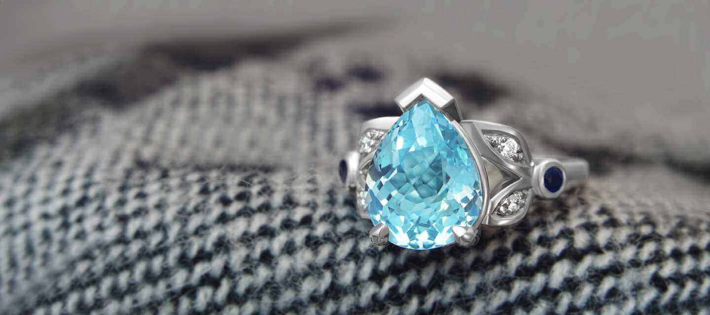 Pear cut blue stone ring on material