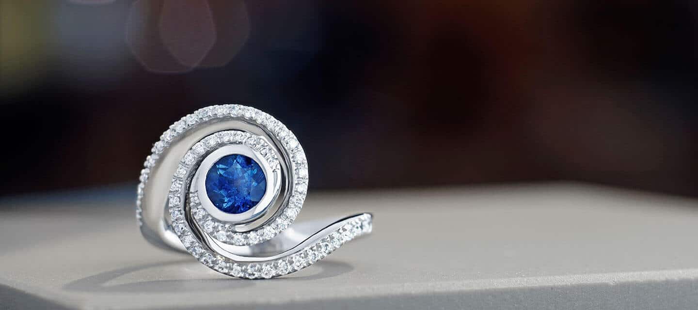 Swirling ring with a blue sapphire and diamonds