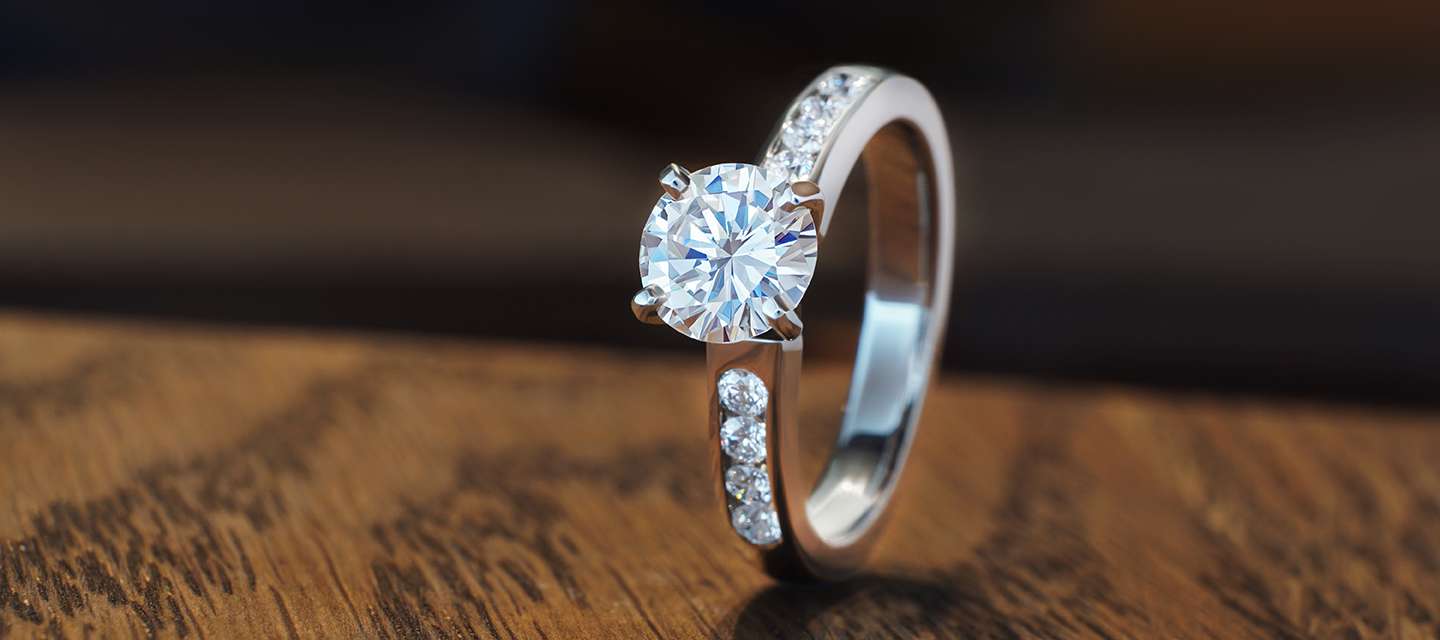 Brilliant cut diamond engagement ring on wood