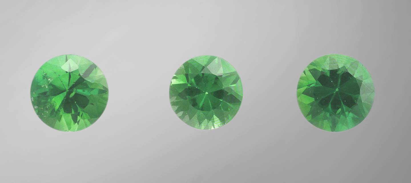 Close up of 3 brilliant cut green gemstones