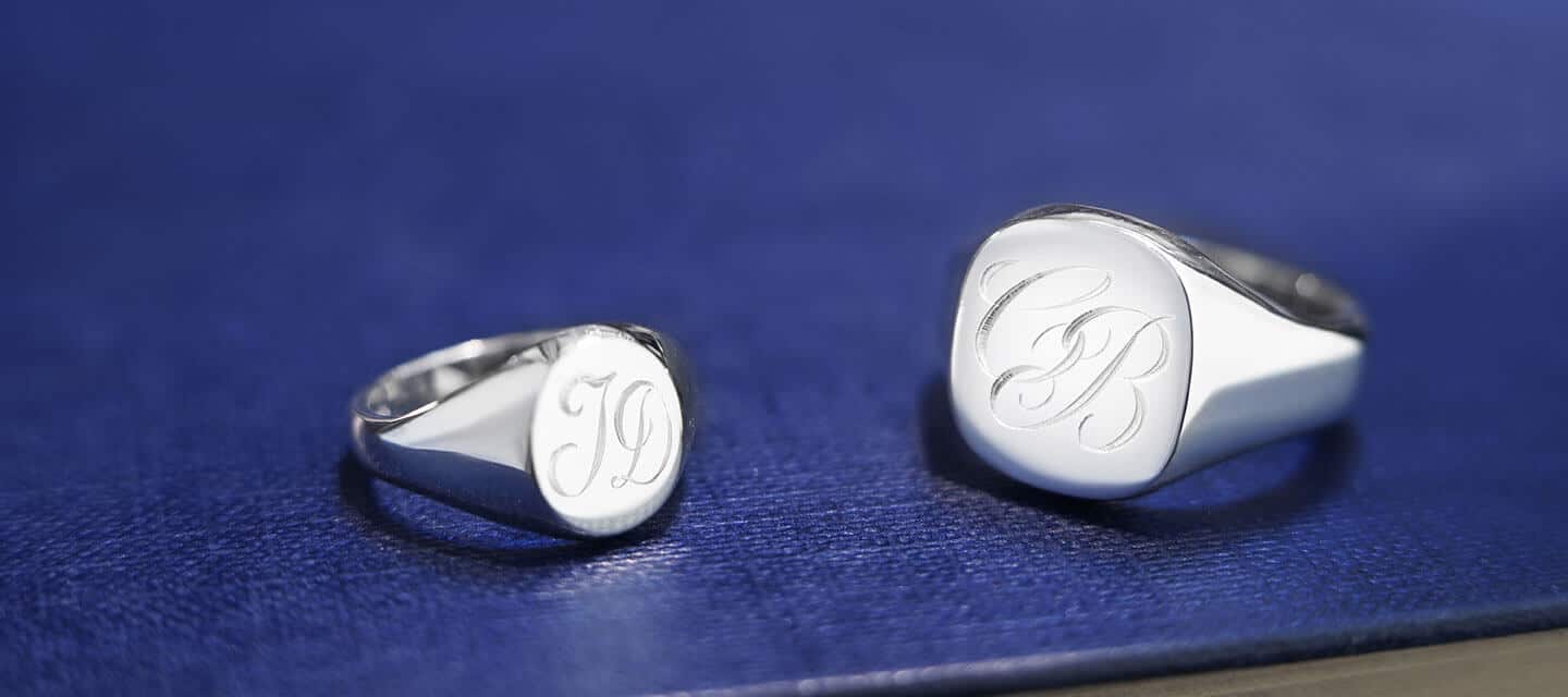 2 signet rings with engraving on a blue surface