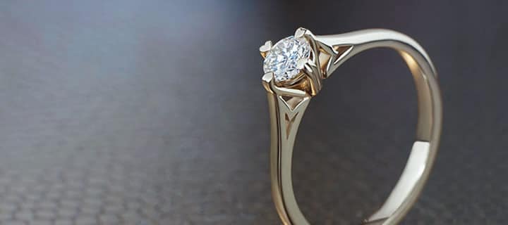 Engagement ring with central diamond set in four claw setting