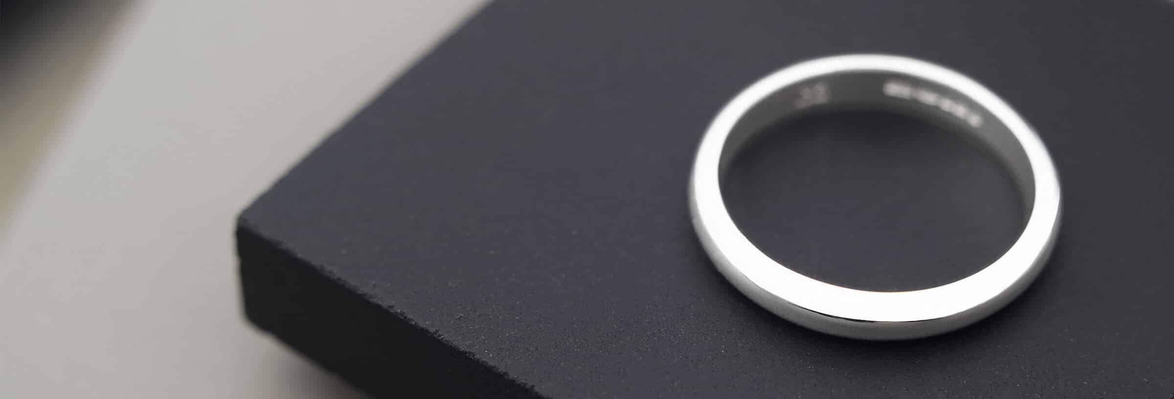 Plain wedding ring on black surface