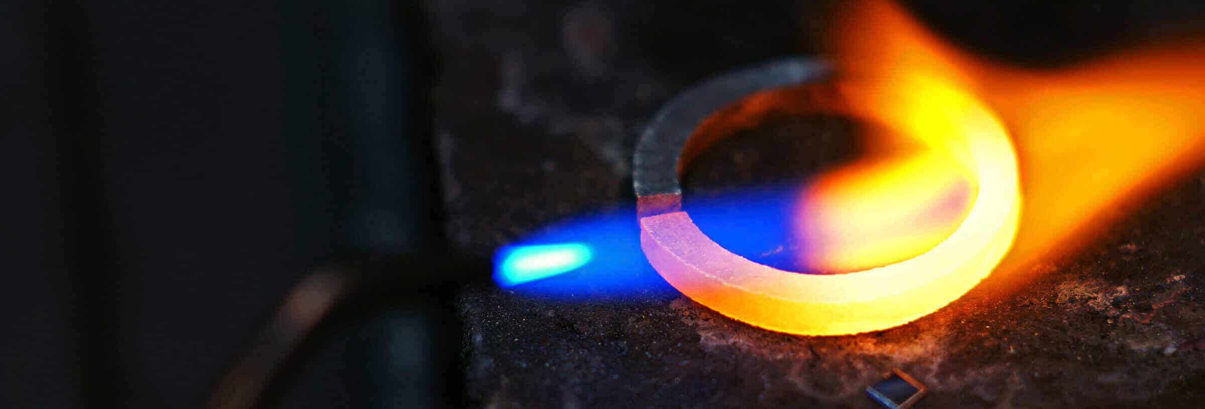 Flame forming a wedding band on workbench