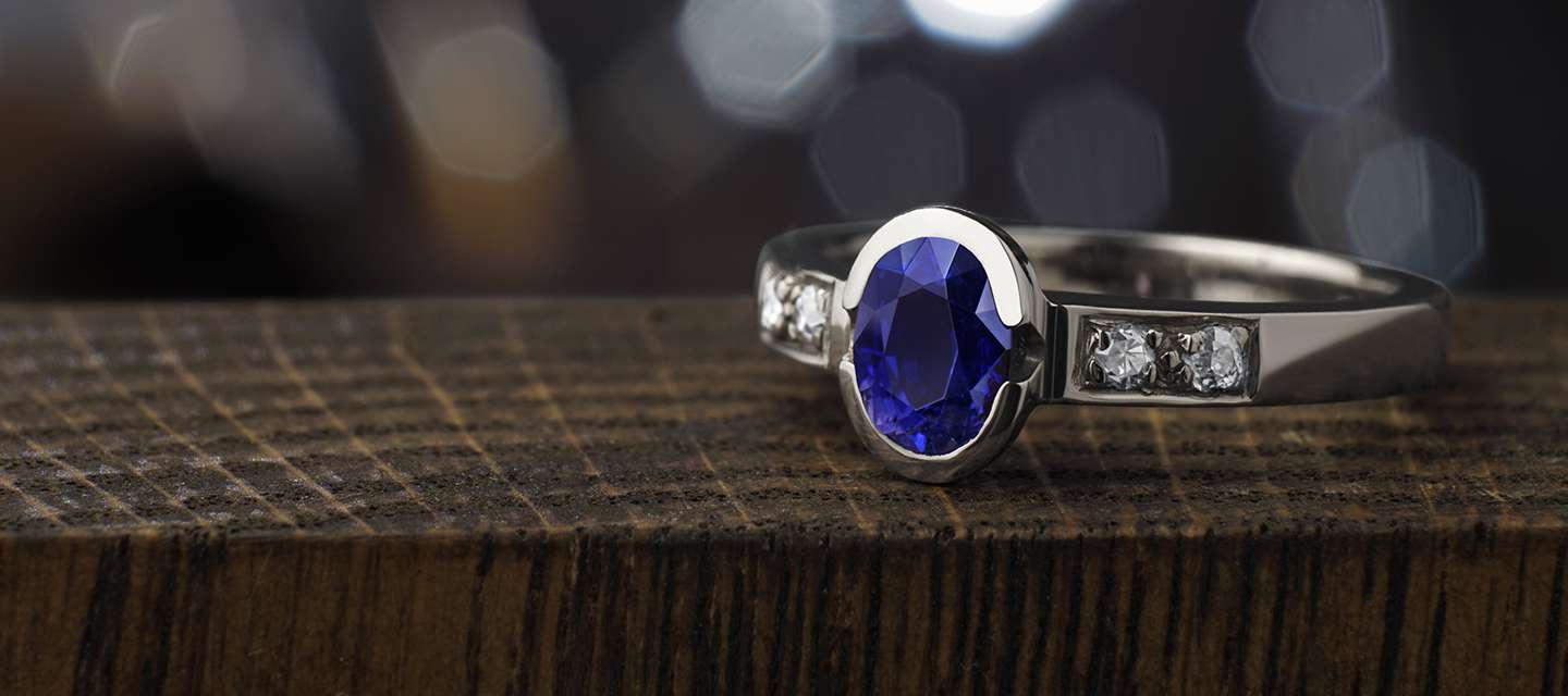 Sapphire and diamond ring on wooden surface