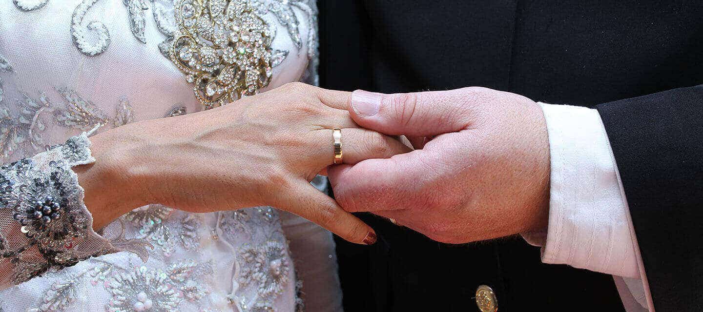 Closeup of bride and groom holding hands