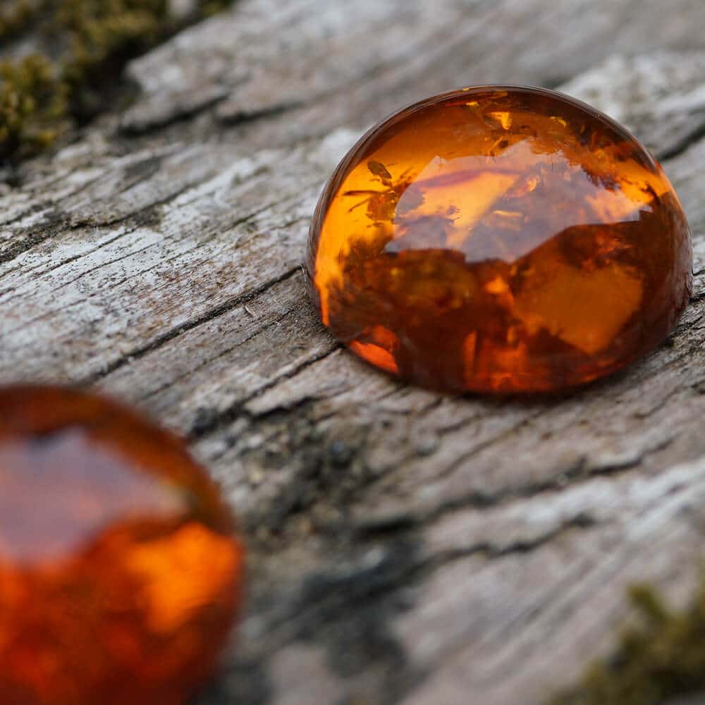 two cabochon amber on wood