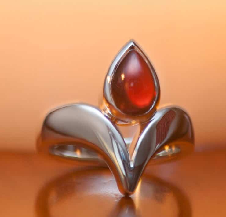 modern orange carnelian dress ring with a candle close up