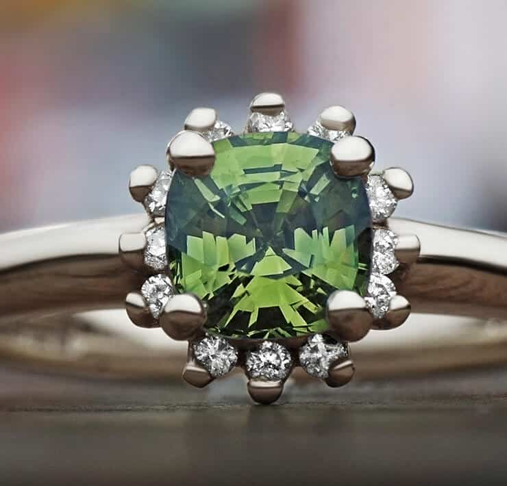 front facing green tsavorite ring with diamond halo close up