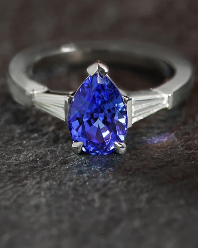 dark blue pear shaped tanzanite in art deco shaped ring