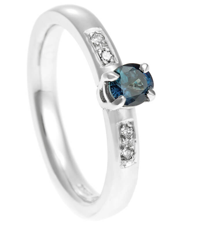 platinum ring with central gemstone and side diamonds