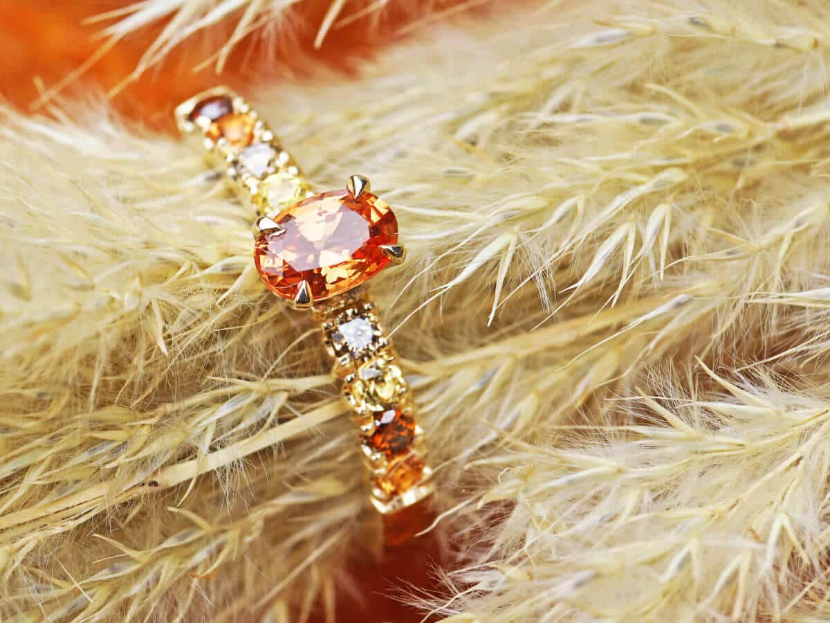 orange sapphire and gold multigem ring around feathers