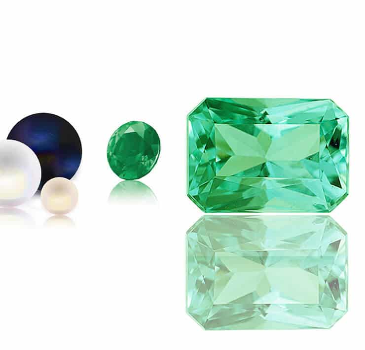 Multiple gemstones including two green emeralds