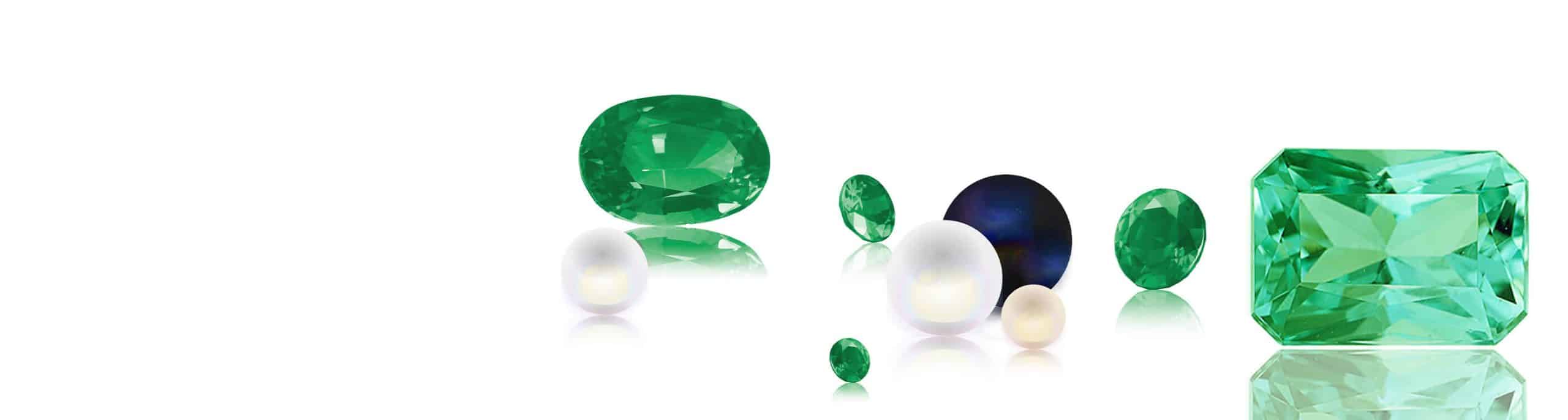 Multiple gemstones including two green emeralds