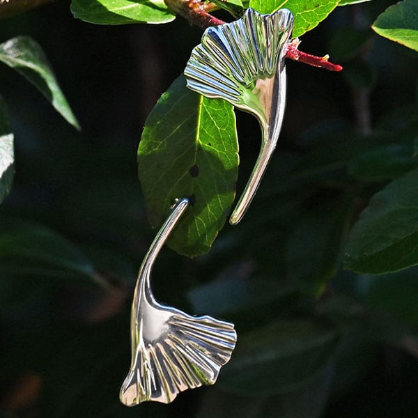 pair of leaf shaped silver earrings in foliage