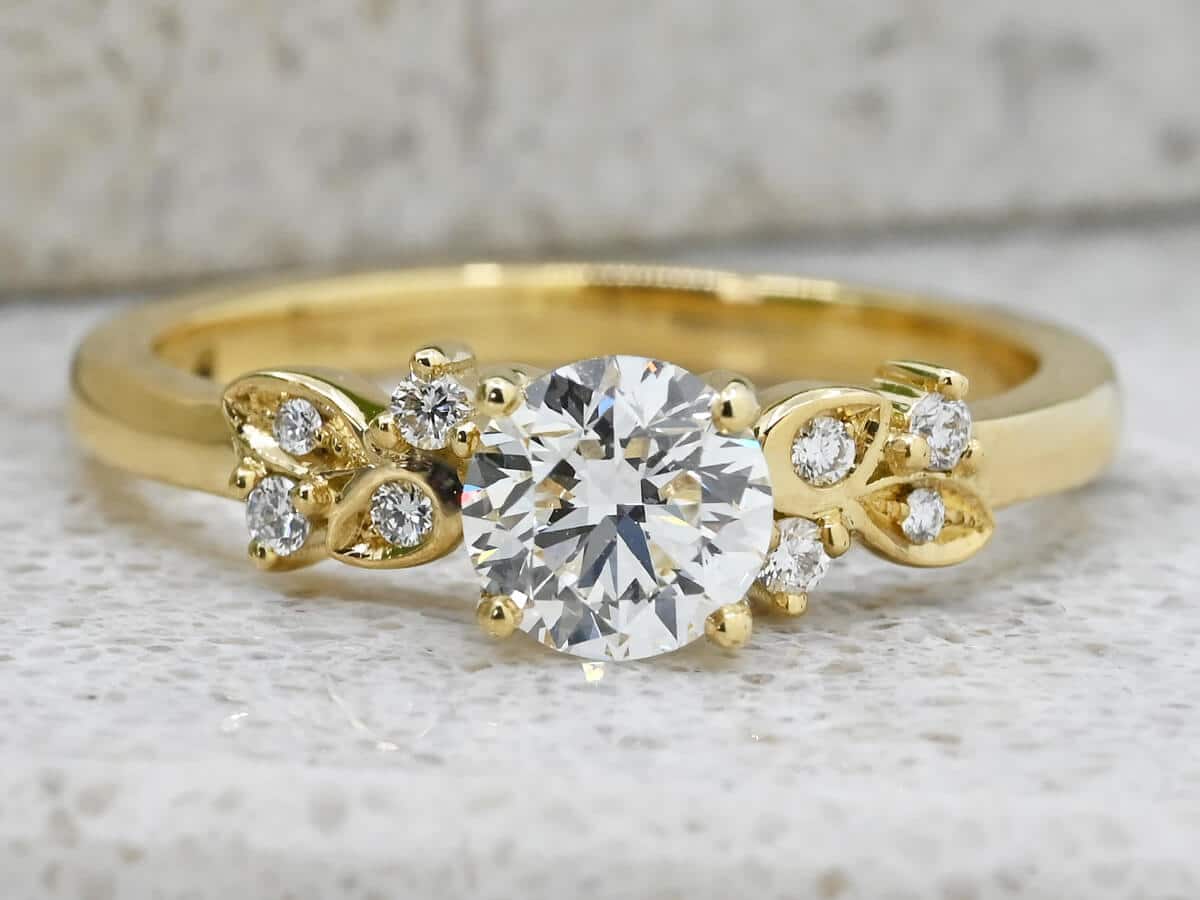 diamond and gold engagement ring with leaf shaped detail