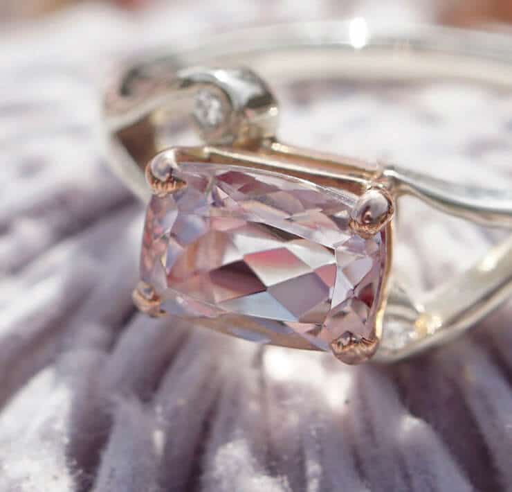 pink cushion shaped morganite in silver ring on flower close up