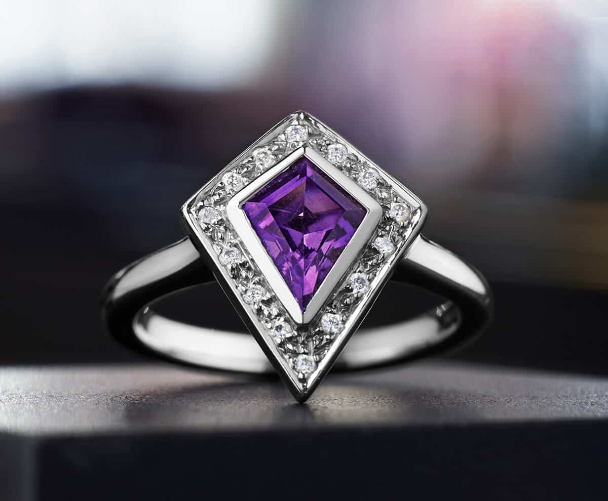 Deep purple kite shaped amethyst ring with smaller diamond gemstones