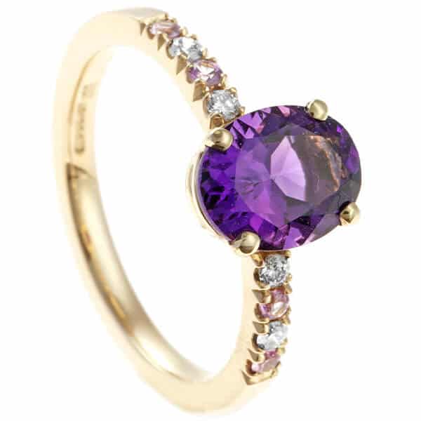 oval purple sapphire with side stones in gold ring