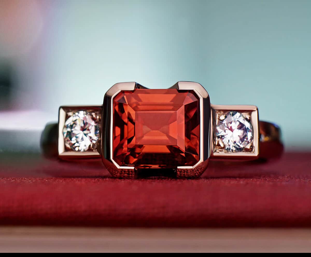 Red zircon and diamond engagement on red cloth