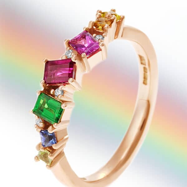 multicoloured gemstone ring with rainbow behind