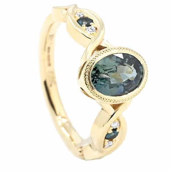 oval teal sapphire with yellow gold engagement ring