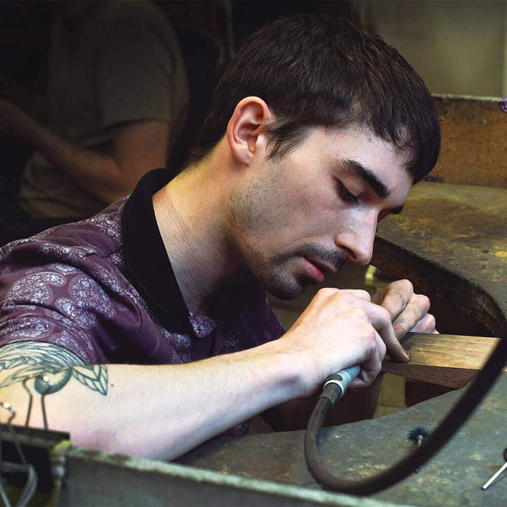 Young jeweller with tattoos making jewellery