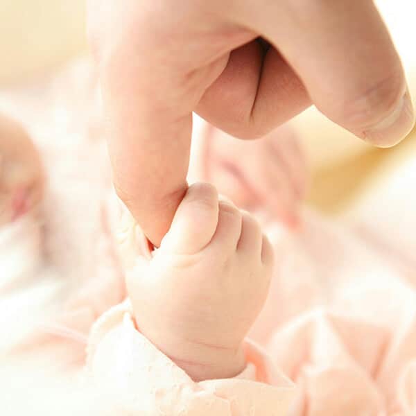 baby holding parent's finger