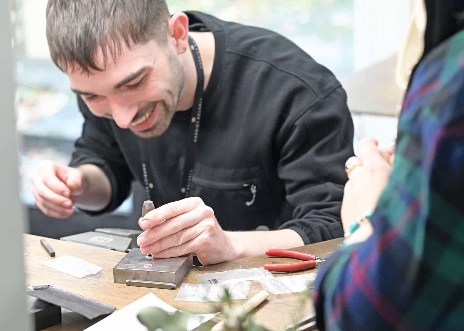 smiling goldsmith with stamp tool