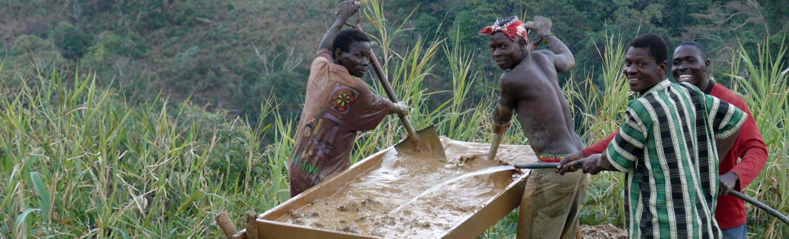 group of ethical precious metal miners with tray of silt