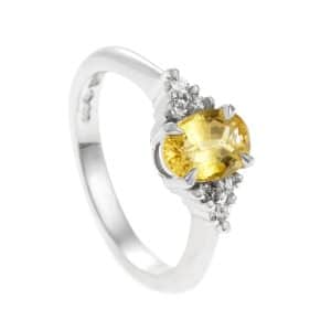 White metal ring with oval yellow sapphire