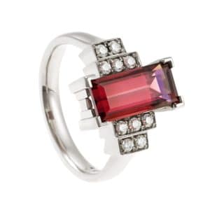 Ring with red gemstone and step design diamonds