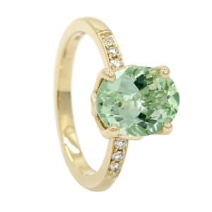 Green oval gemstone and diamond ring