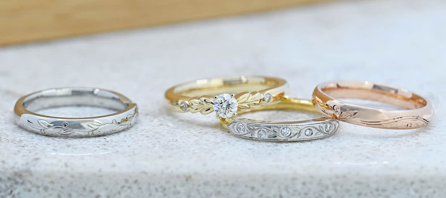 4 different gold rings on white surface