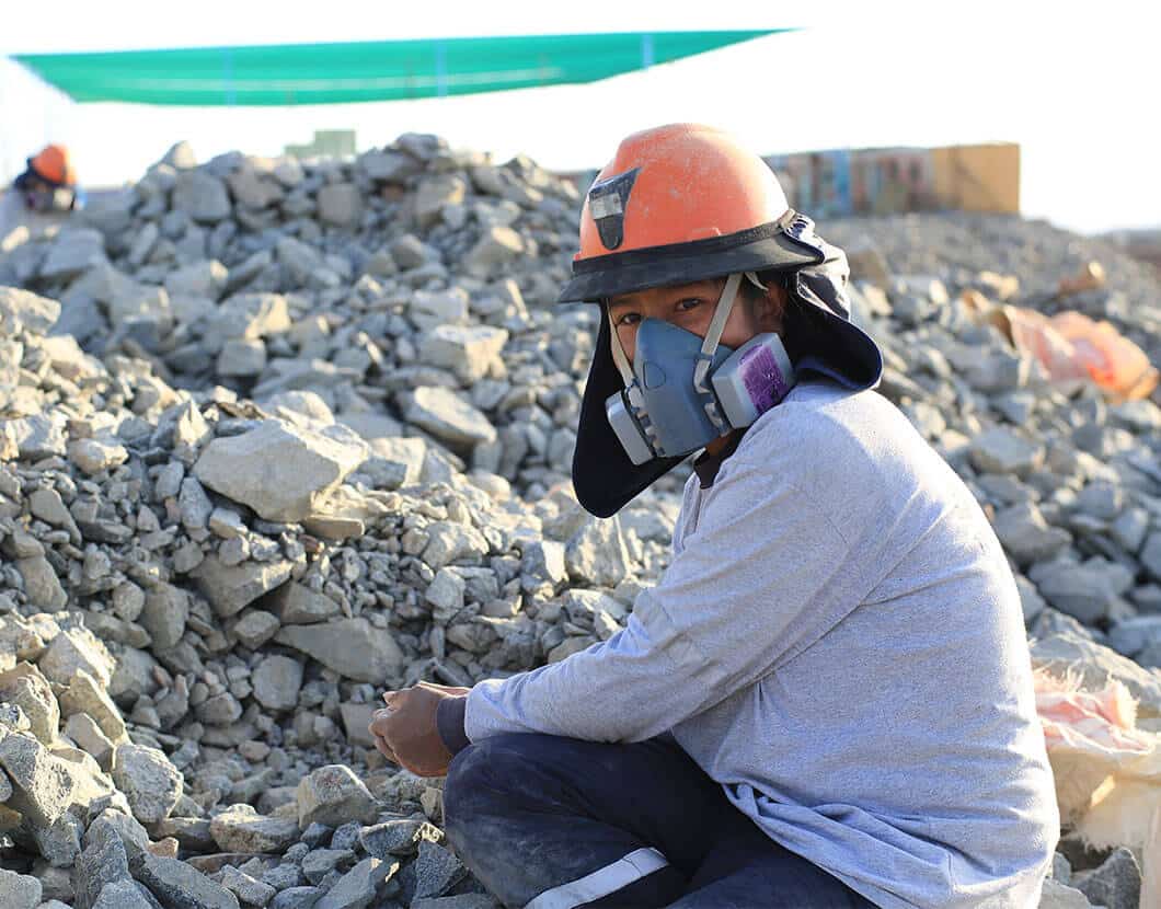 masked gold miner with rocks