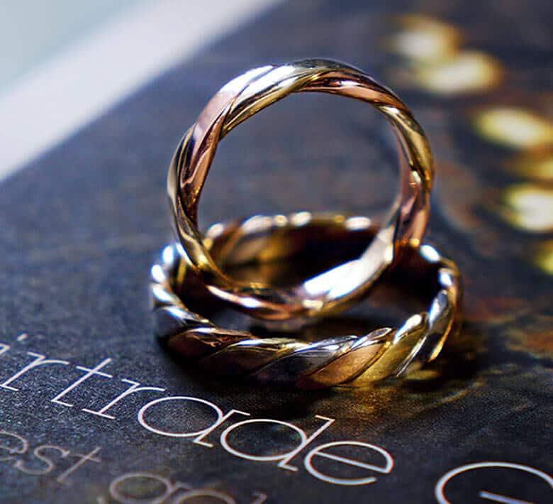 pair of twist style wedding rings on Fairtrade book