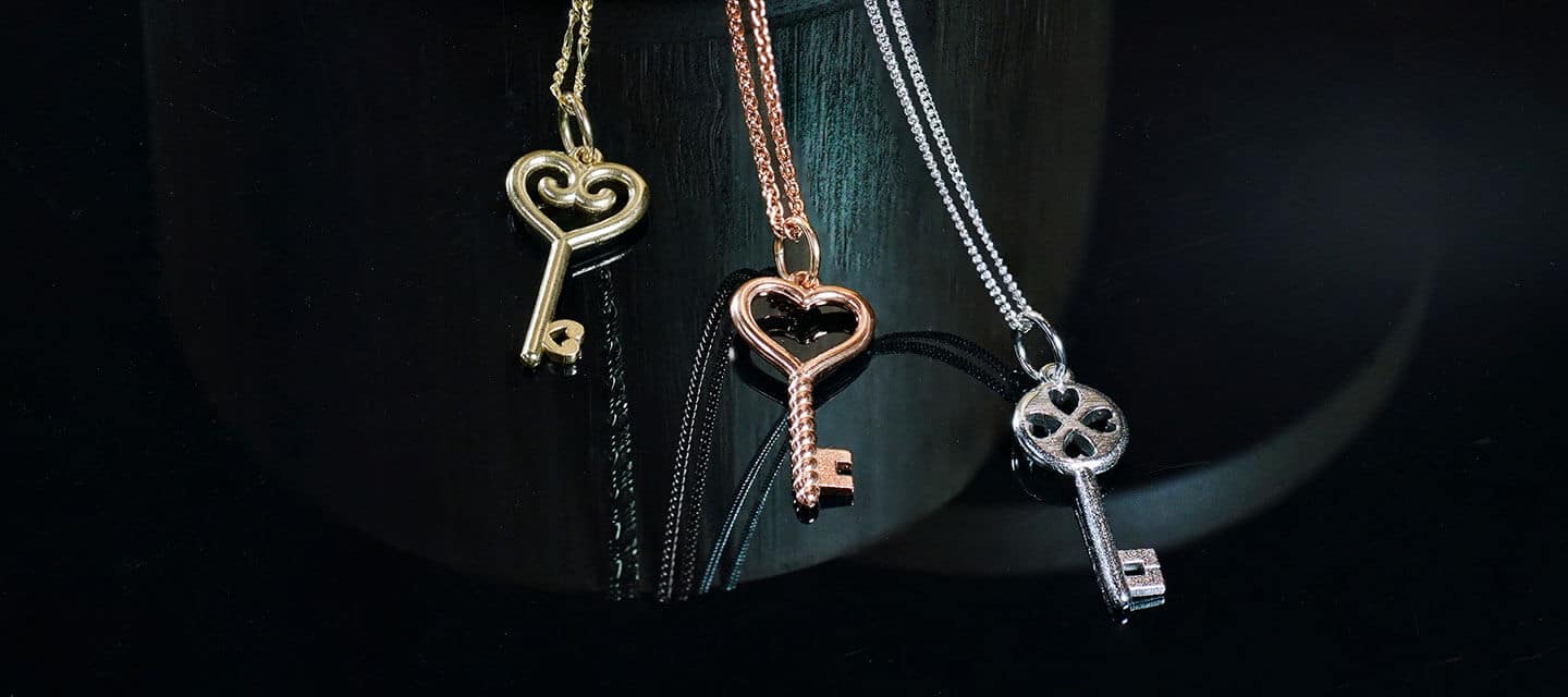 3 different metal key pendants on chains - gold, bronze and silver with different designs