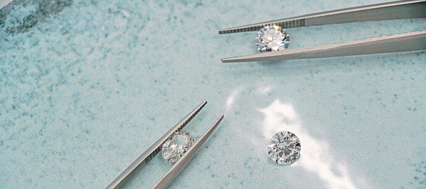 3 diamonds with 2 in metal tweezers