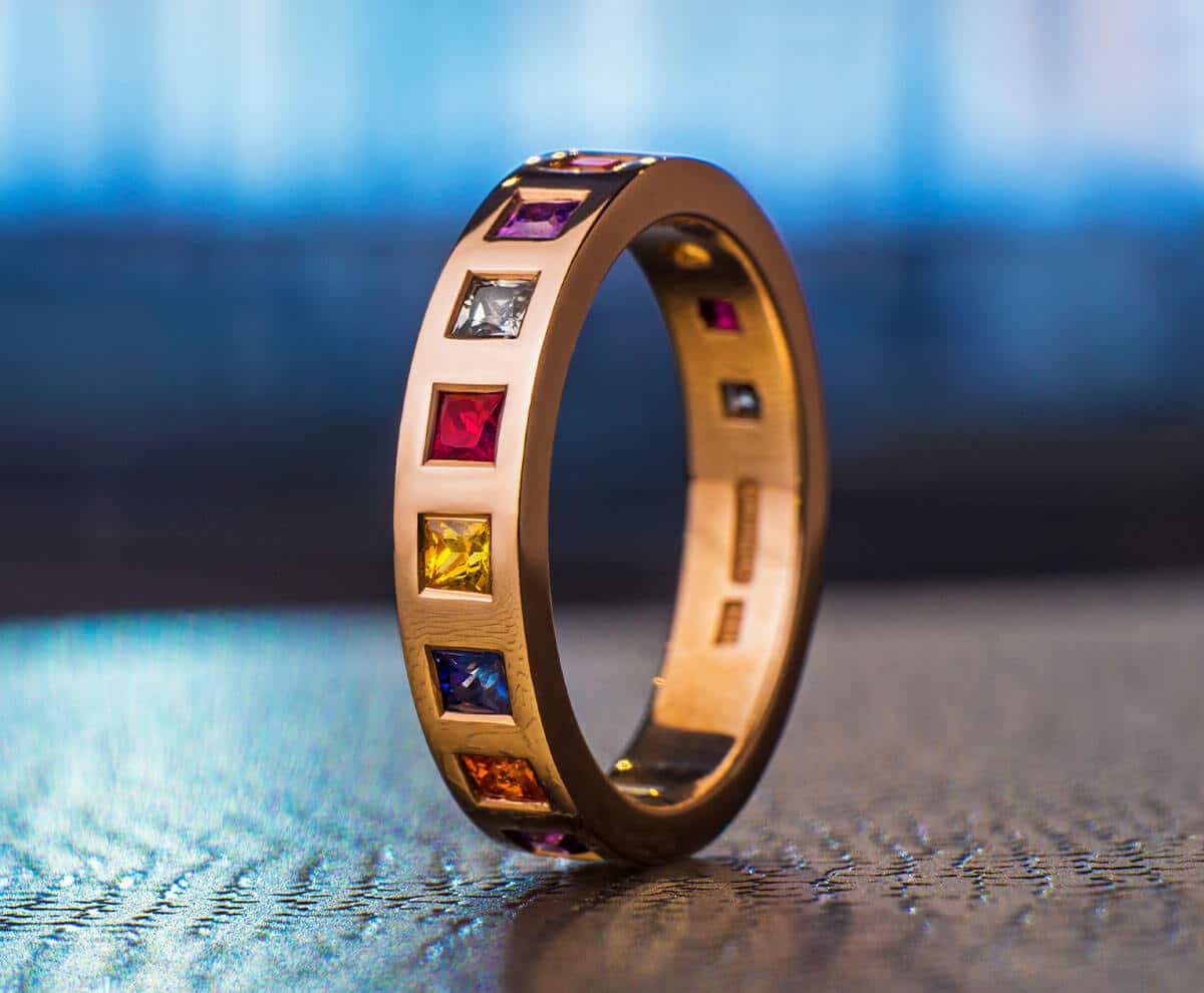 gold eternity ring with square multicoloured gemstones