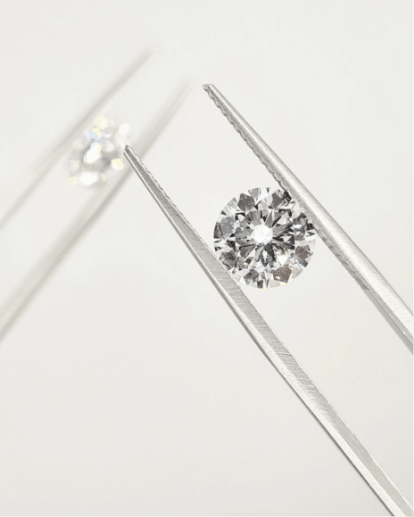 Two round diamonds in tweezers